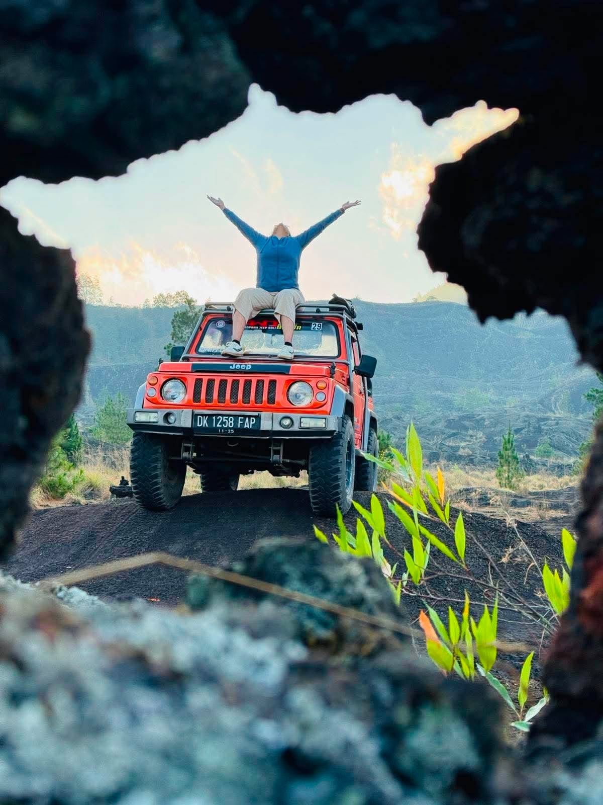 Traveller on an orange jeep overlooking Mount Batur, Bali